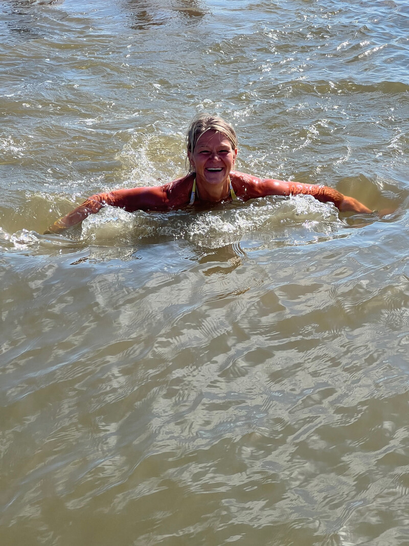 Lachende Person schwimmt im Wasser der Nordsee