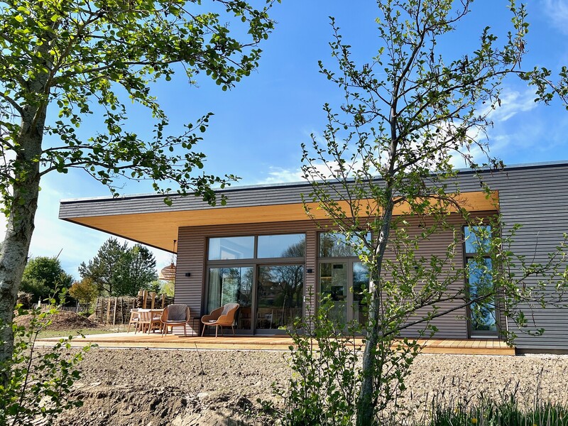 Modernes Designhaus mit Holzfassade, Panoramafenstern und überdachter Terrasse am Warfthof Wollatz
