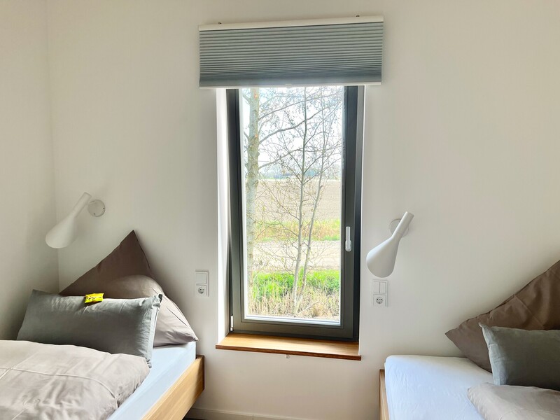 Zweitschlafzimmer im Haus NordseeLuft mit zwei Einzelbetten am Fenster mit Feld- und Naturblick