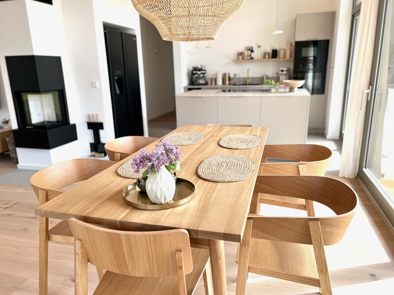 Wohnzimmer im Haus NordseeZeit mit Kaminofen, Fernseher, Holz-Sideboard und Fensterfront zur Terrasse