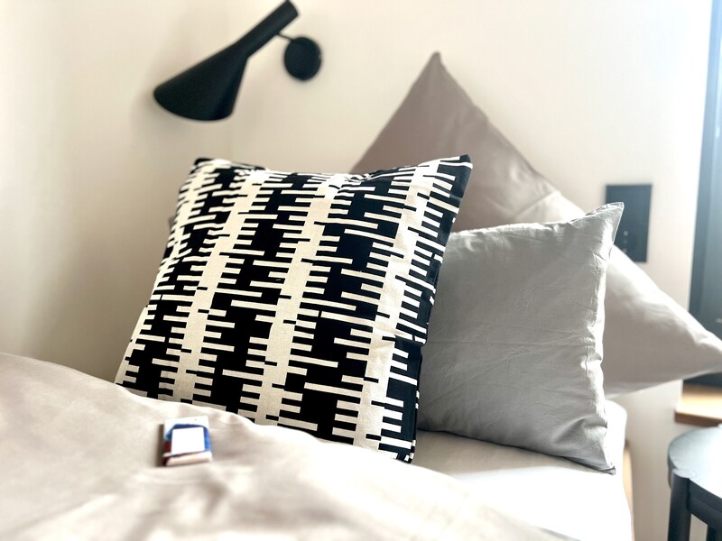 Bett-Detail im StrandHaus mit schwarz-weißem und grauen Kissen