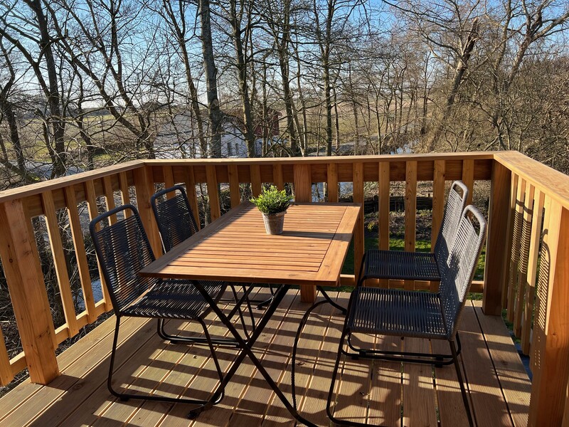 Sonniger Balkon mit Sitzgelegenheit und Blick ins Grüne