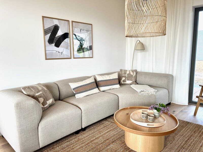 Modernes, helles Wohnzimmer mit Sofa und Holz-Couchtisch